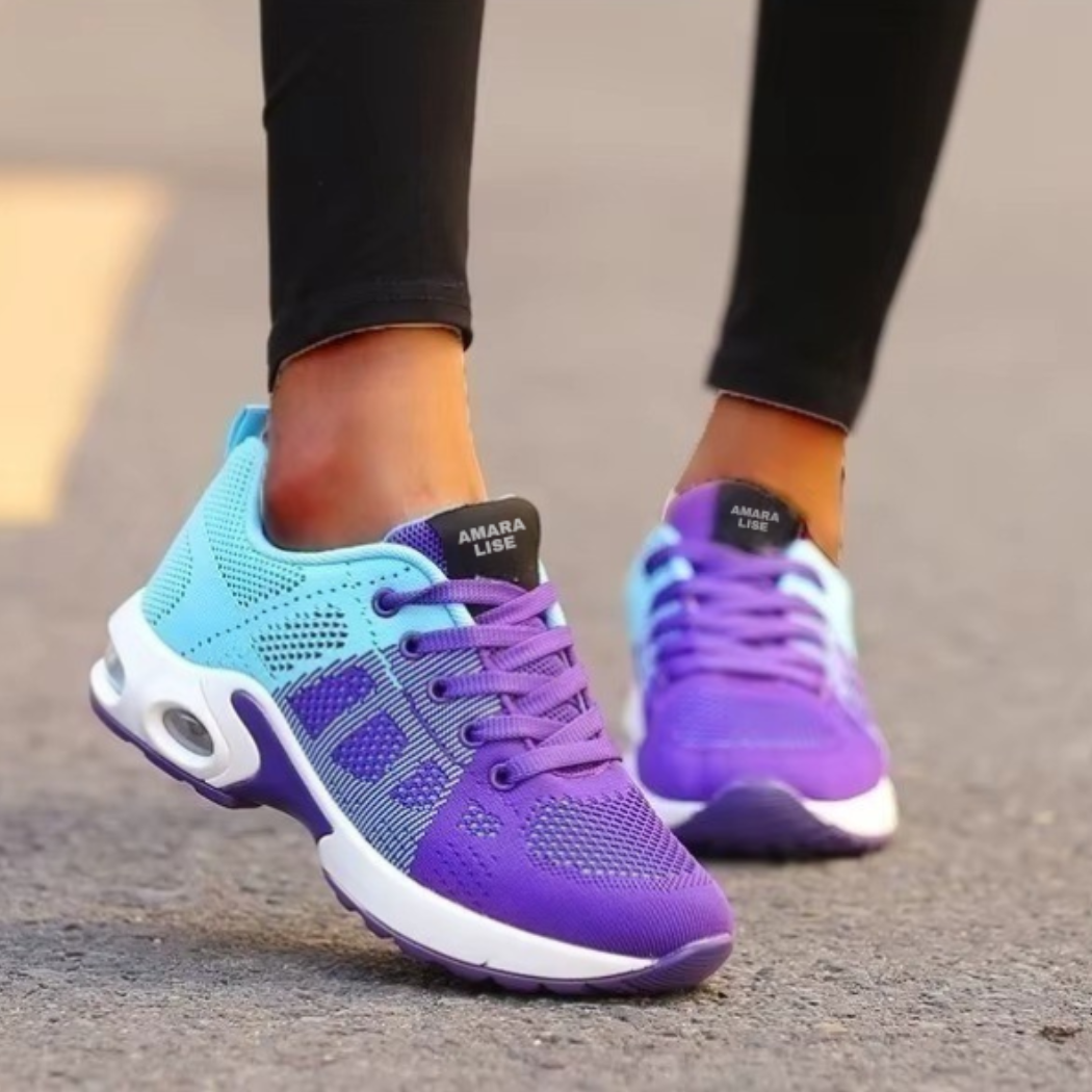Women’s turquoise and purple lightweight knit trainers with cushioned air sole and lace-up design, worn outdoors.