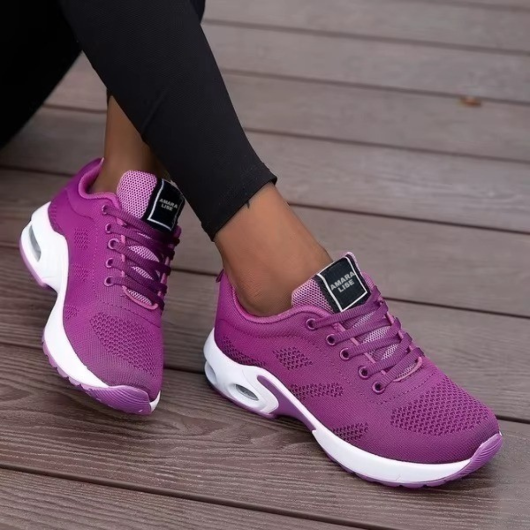 Women’s purple breathable knit trainers with air cushion sole and matching laces, worn with black leggings.
